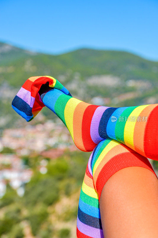 彩色的袜子。抬腿的女人。