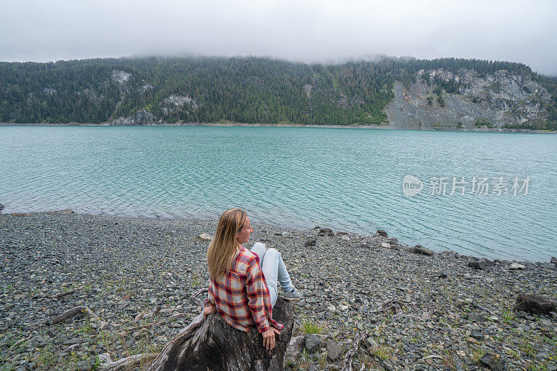 阴天，年轻女子在湖边凝望大自然