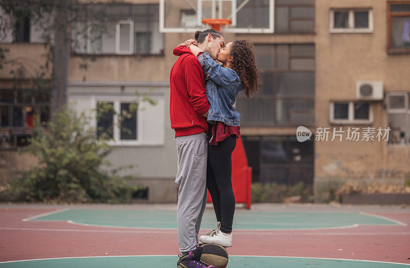 一对情侣在篮球场拥抱