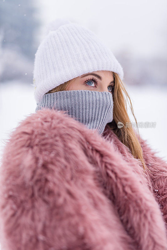 美丽的蓝眼睛少女在一个寒冷的下雪天。