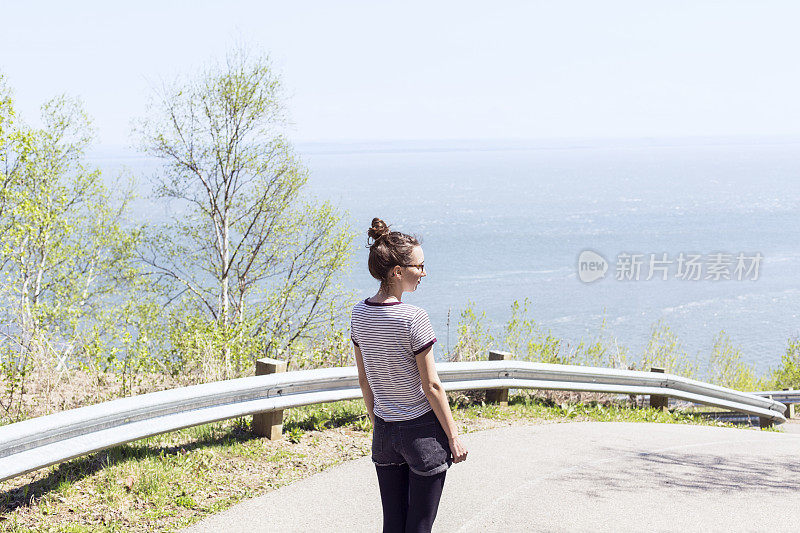 一个年轻女子走在山间蜿蜒的小路上