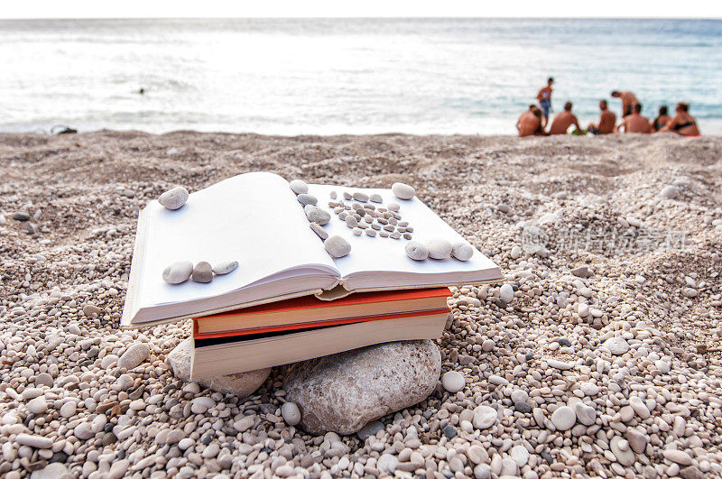 夏日阅读――在沙滩上看书，有人做背景