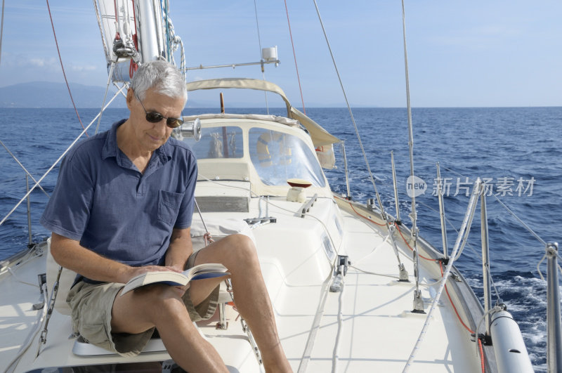 在游艇上看书的男人