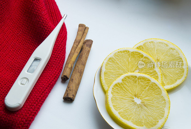 治疗感冒的概念-柠檬，肉桂，温度计，围巾