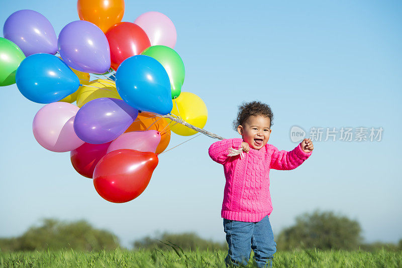 漂亮的小女孩在玩气球。