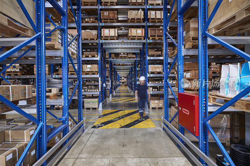 同事走在仓库过道上。