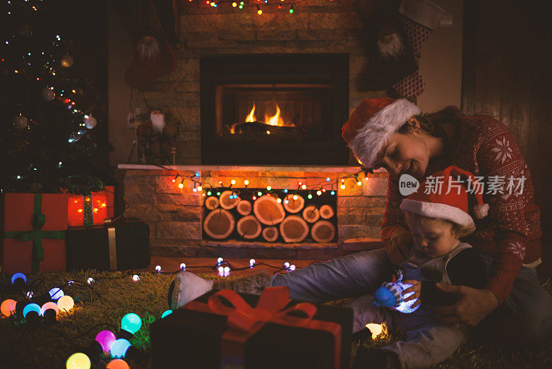 母亲和儿子在圣诞夜的壁炉旁
