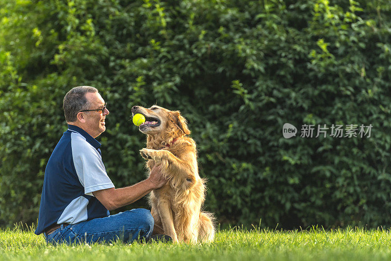 日落时分，一个男人在抚摸他的狗