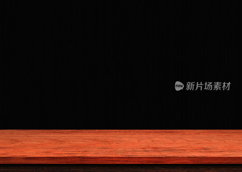 黑色墙壁上的空木桌，用于展示或蒙太奇您的产品。