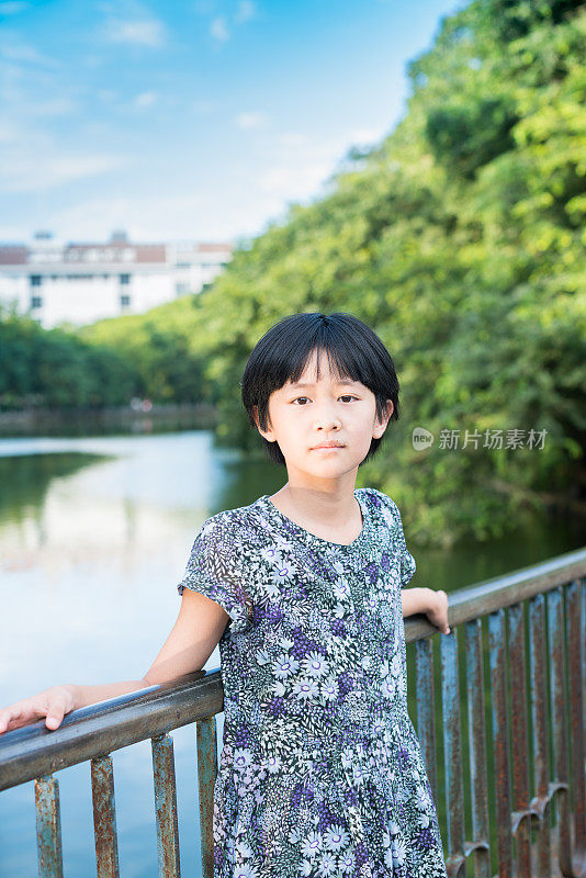 亚洲女孩站在早晨的阳光下的公园里