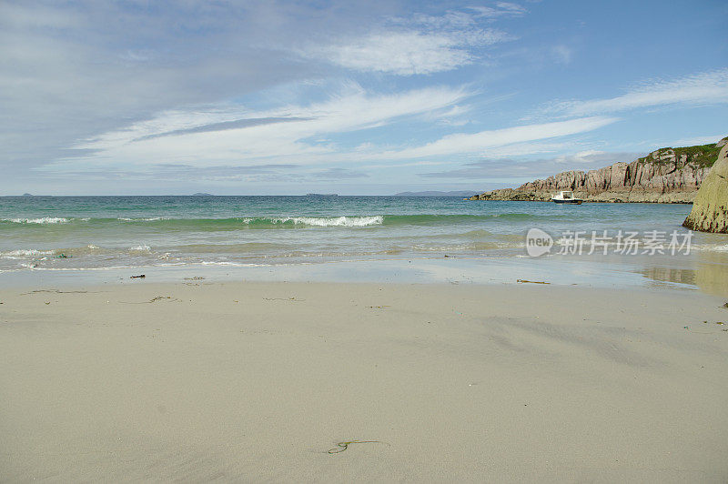 波浪在带有岩石岬角的苏格兰沙滩上破碎