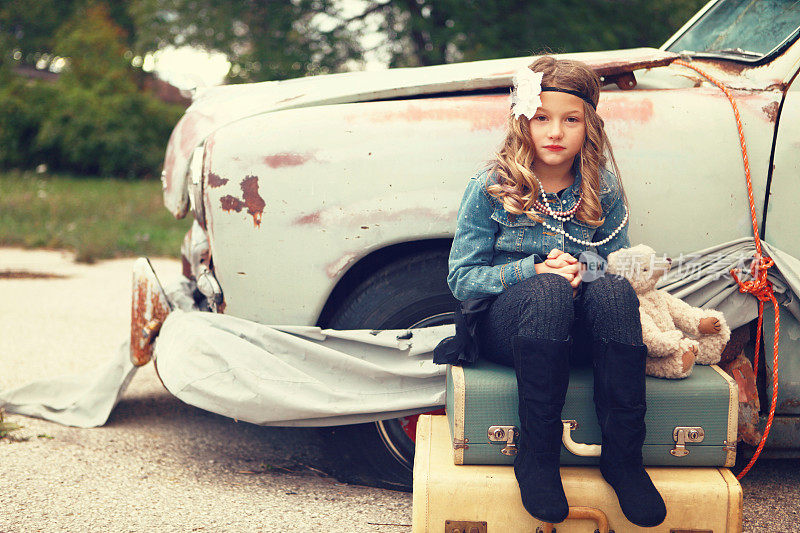 玩具熊和古董车旁的小女孩