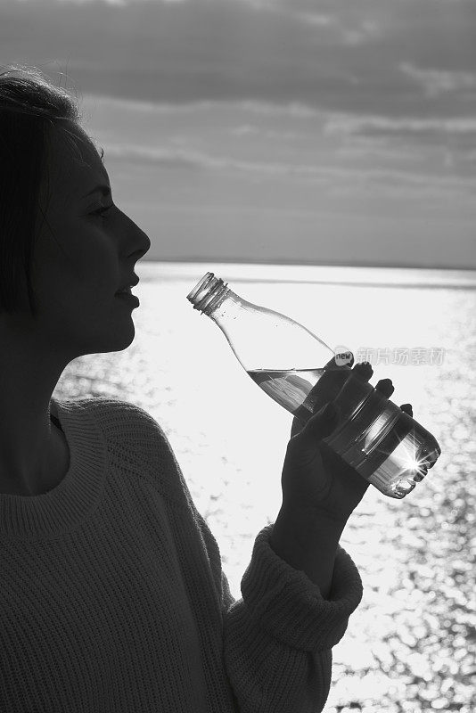 年轻女子拿着黑白相间的水瓶