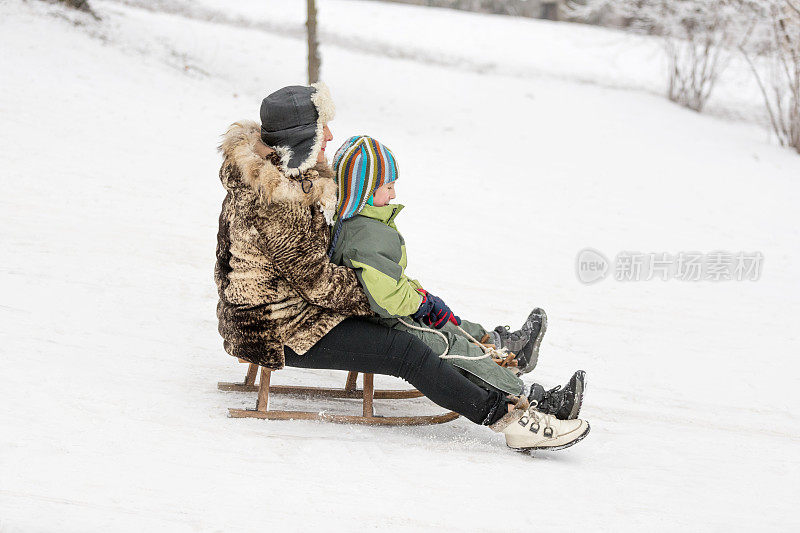 一个男孩和他的奶奶在雪橇上