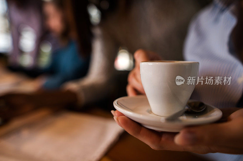 女人手里拿着白咖啡杯。