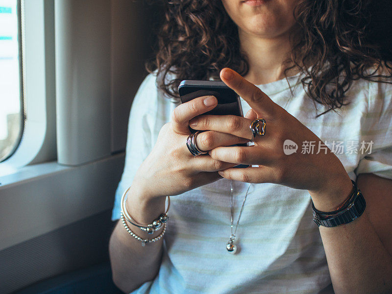 年轻女子在火车上使用手机