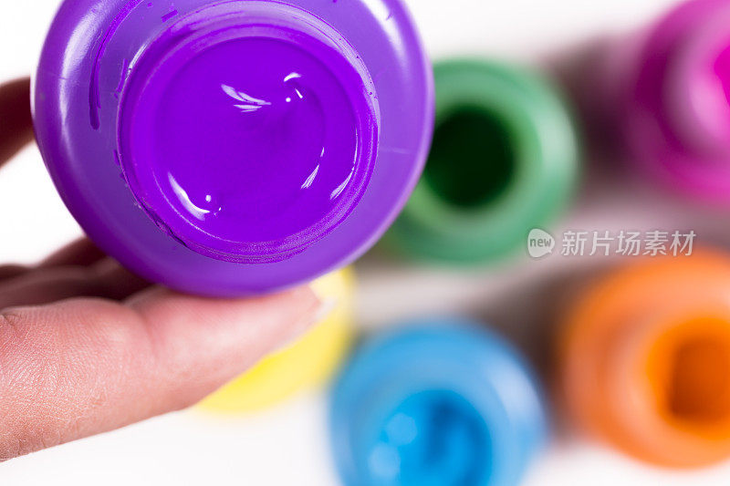 工艺美术:艺术家拿着一罐紫色的颜料。
