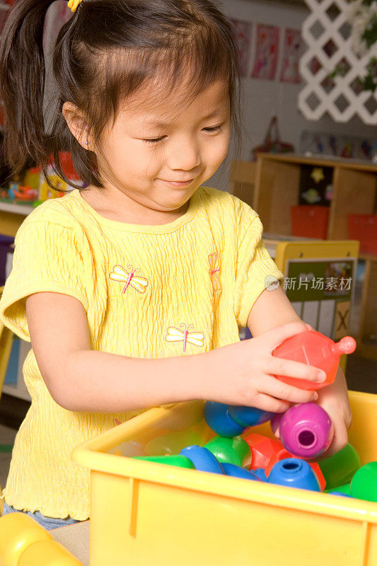 小女孩在幼儿园玩玩具