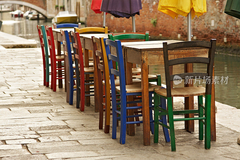 威尼斯露天餐厅的桌子和五颜六色的雨伞
