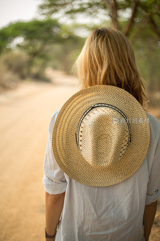 沙漠路上戴着草帽的女人