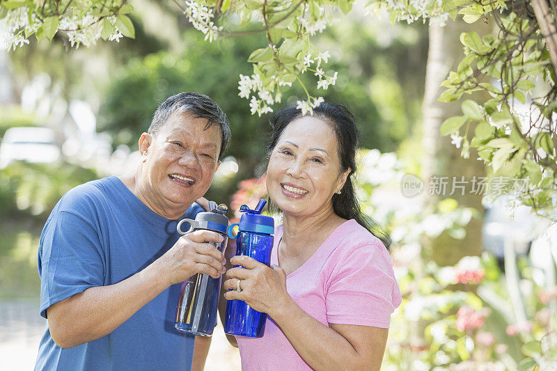 年老的亚洲夫妇在公园里喝水