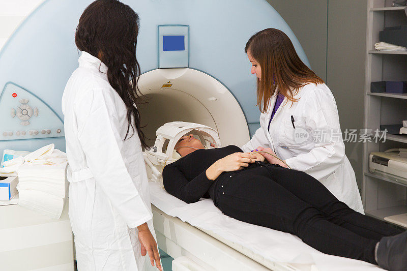 MRI扫描的女性，黑人技术员和她的同事帮助