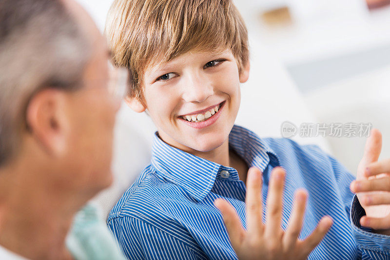 微笑的少年和他的父亲说话。