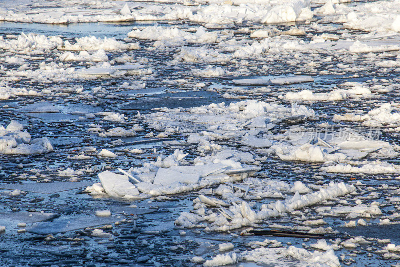 结冰的河流上覆盖着积雪的大冰块碎片