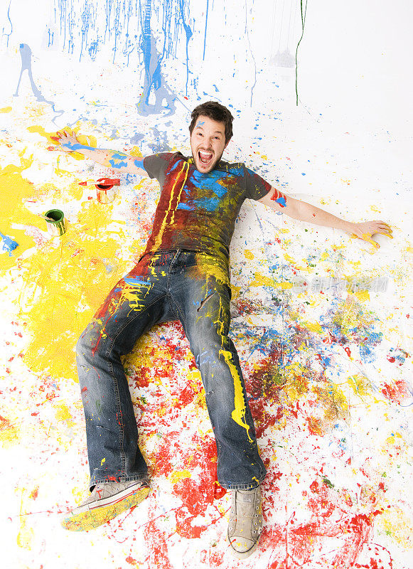 画家躺在地上，身上涂满了颜料