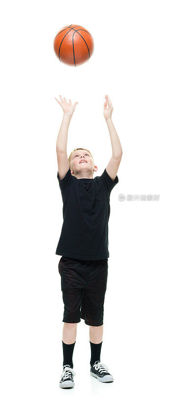 微笑的小男孩在玩篮球