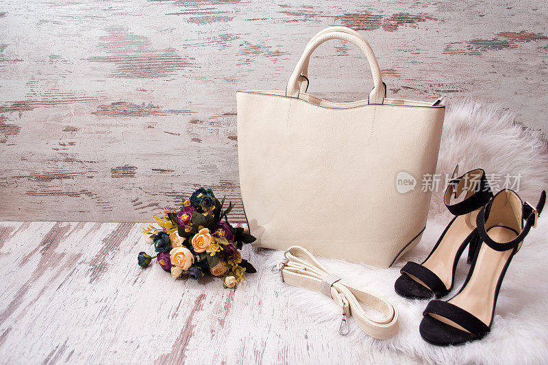 时尚的概念。轻包，黑鞋和花在白色的背景。本空间