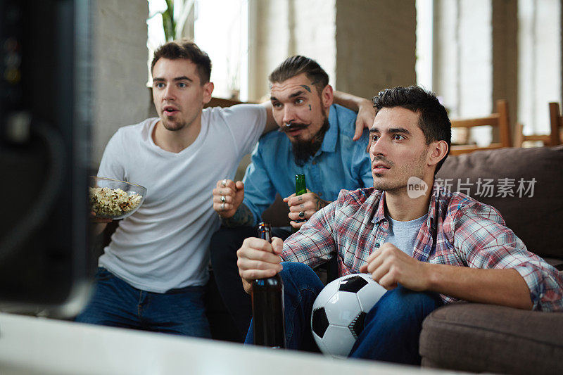 情绪激动的球迷在电视上看比赛