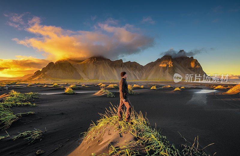 在冰岛的韦斯特拉霍恩和它的黑色沙滩上享受日落的徒步旅行者