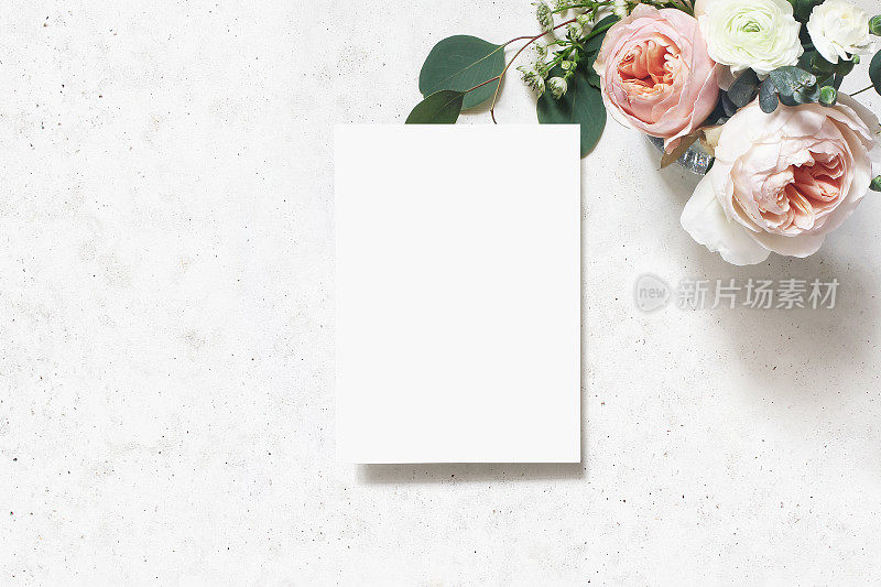 女性婚礼，生日模拟场景。空白纸贺卡。一束粉红色的英国玫瑰，毛茛花和桉树叶。具体表的背景。平躺，俯视图。