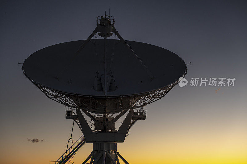 日落天空下的碟形卫星天线