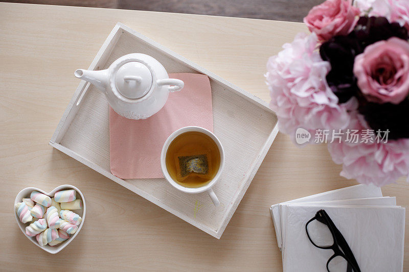 茶，糖果，花和书在咖啡桌上