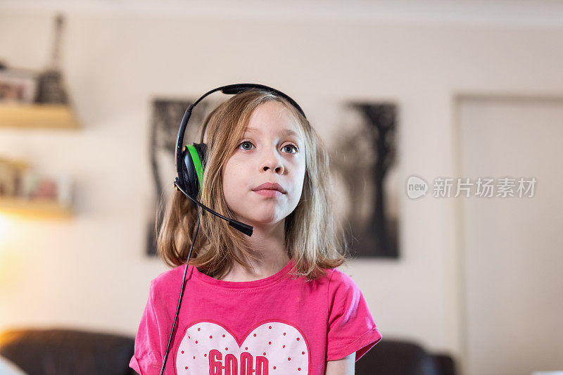 年轻女孩戴着耳机在线游戏
