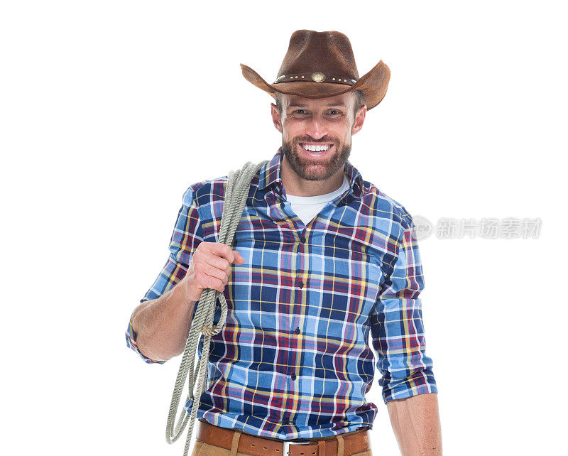 白人年轻男性牛仔戴着牛仔帽，手持套索，用绳子站在白色背景前