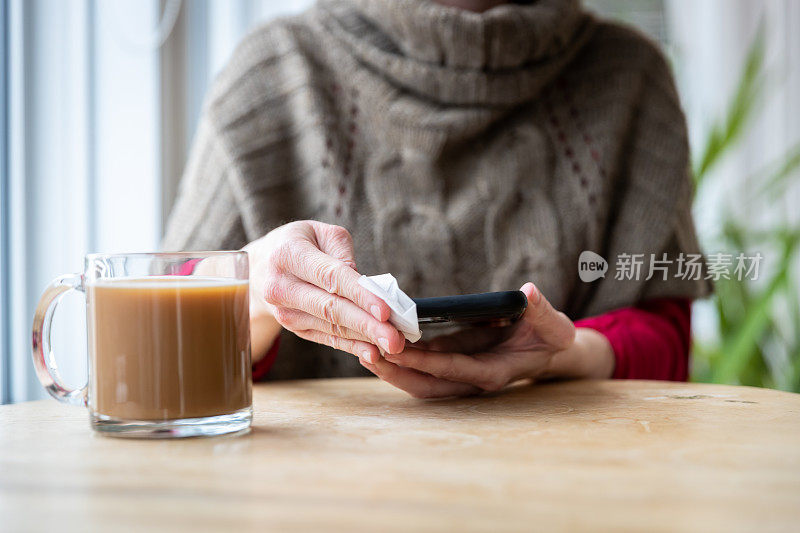 女性用抗菌白色纸巾或一次性湿巾清洁智能手机显示屏