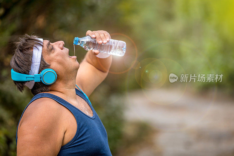 喝水的时间到了。一个在剧烈运动后大口呼吸和喝氨基酸的超重男子