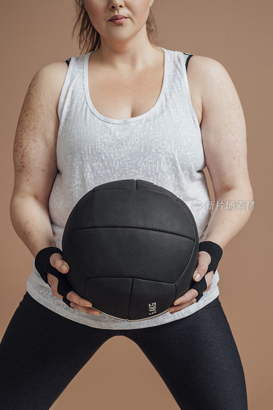 加大小的白人妇女锻炼与药球，健身房的概念