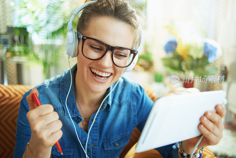 带着白色耳机和平板电脑的快乐女人在网上学习