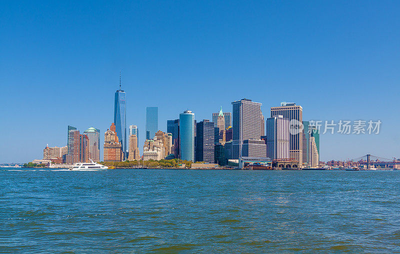 曼哈顿金融区，世界贸易中心，纽约港水，炮台公园和蓝天。