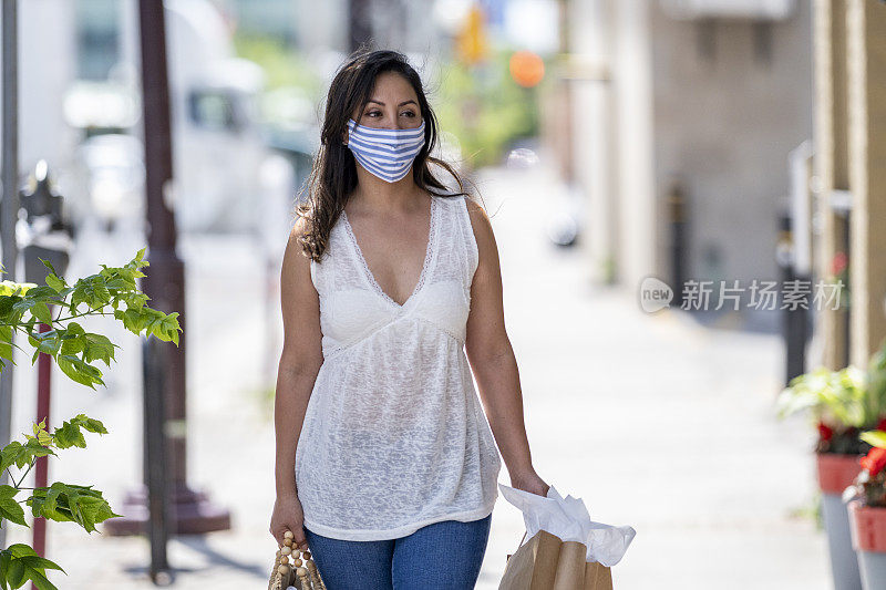 一名西班牙妇女戴着防护面具在市中心购物