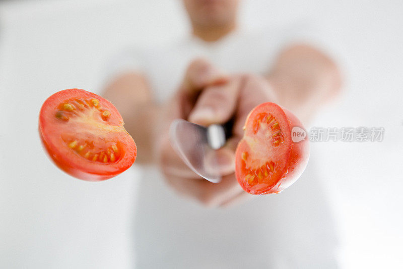 西红柿在空中用一把锋利的刀切着