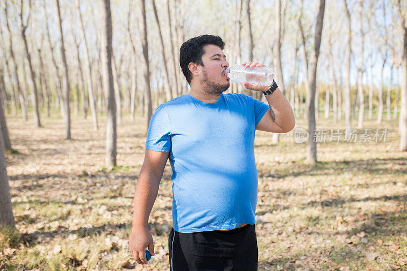 男人在户外运动后喝水