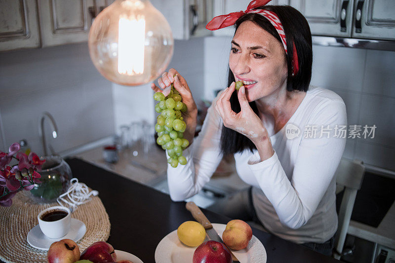 健康成熟的女人早餐吃健康食品——水果