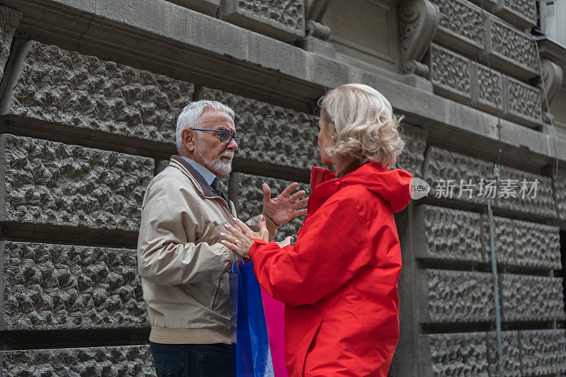 一对愤愤不平的退休老人在城市里散步并愤怒地辩论。