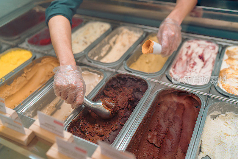 冰淇淋咖啡馆的工作人员正在供应一勺冰淇淋