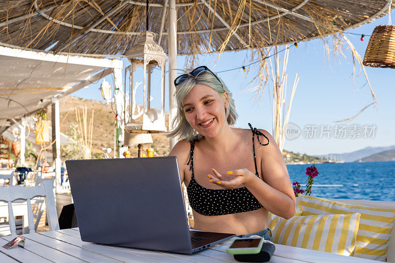 一个年轻女人在海滩上视频通话